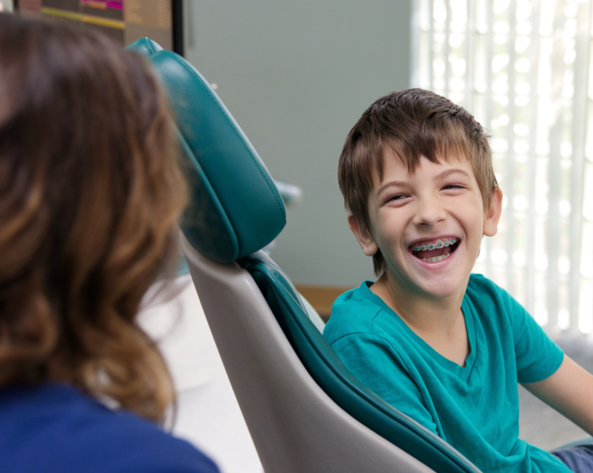 young boy smiling with braces during appointment
